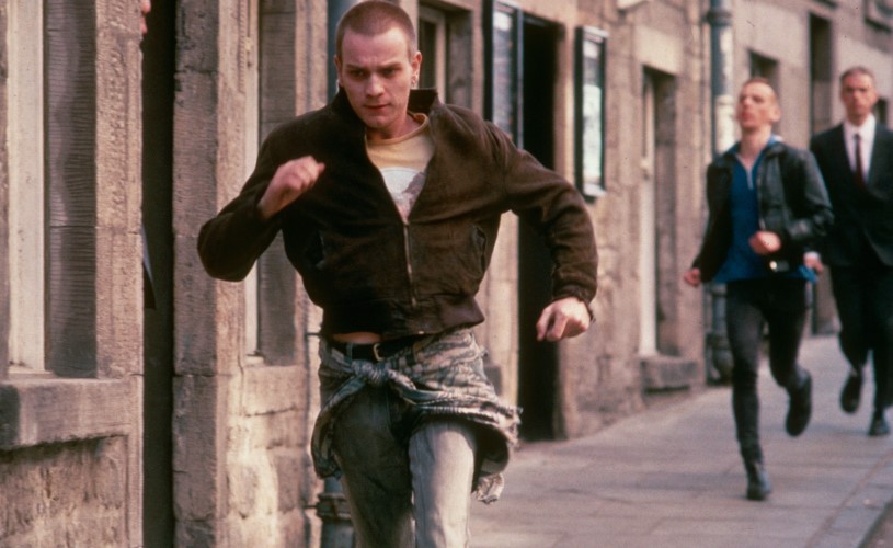 Man running away while three men chase behind